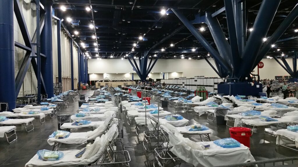 pexels photo 3993317 3993317 Large indoor temporary medical station with rows of prepared hospital beds and supplies.